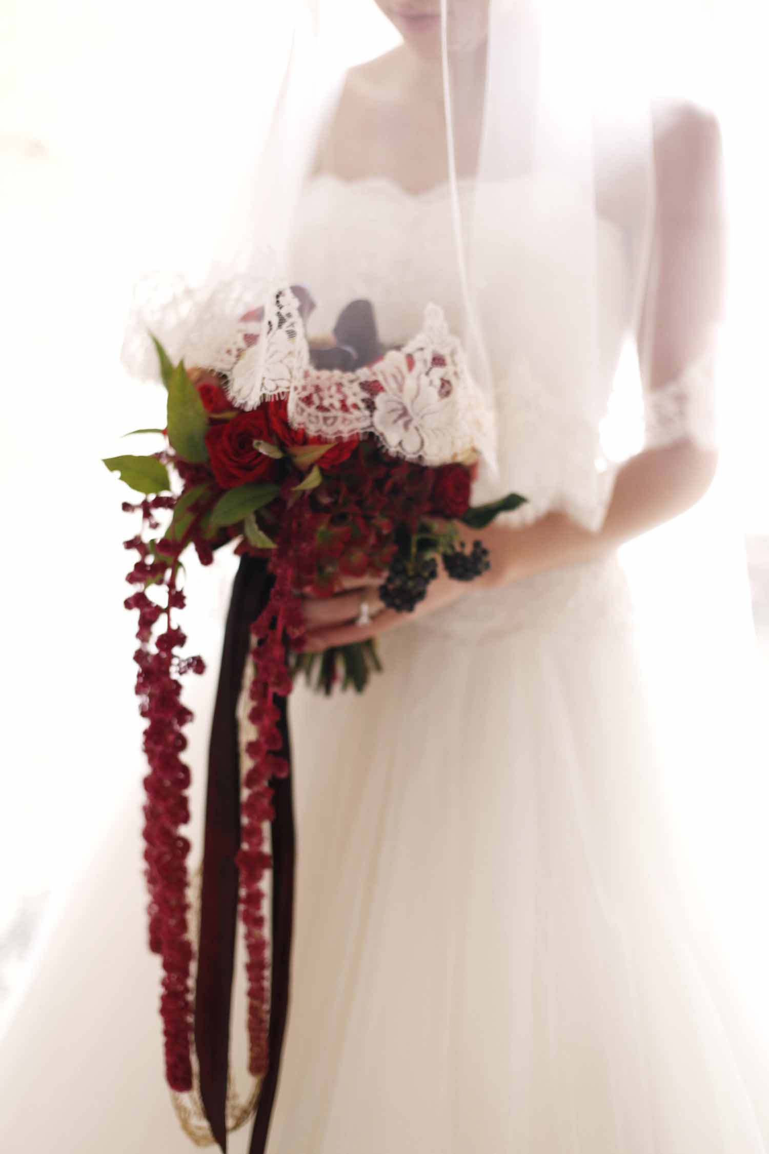 Bride holding bouquet of red roses and red trailing amaranthus - Flora Nova Design Seattle