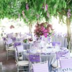 greenery and purple flower overhang at wedding reception
