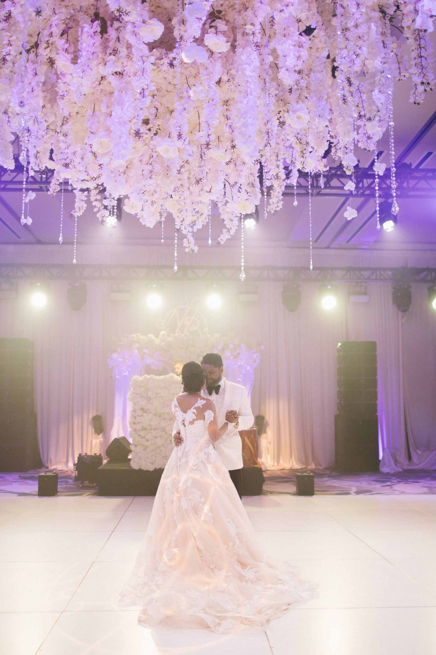 Beautiful white floral chandelier installation suspended above the dance floor for this luxe ballroom Seattle wedding