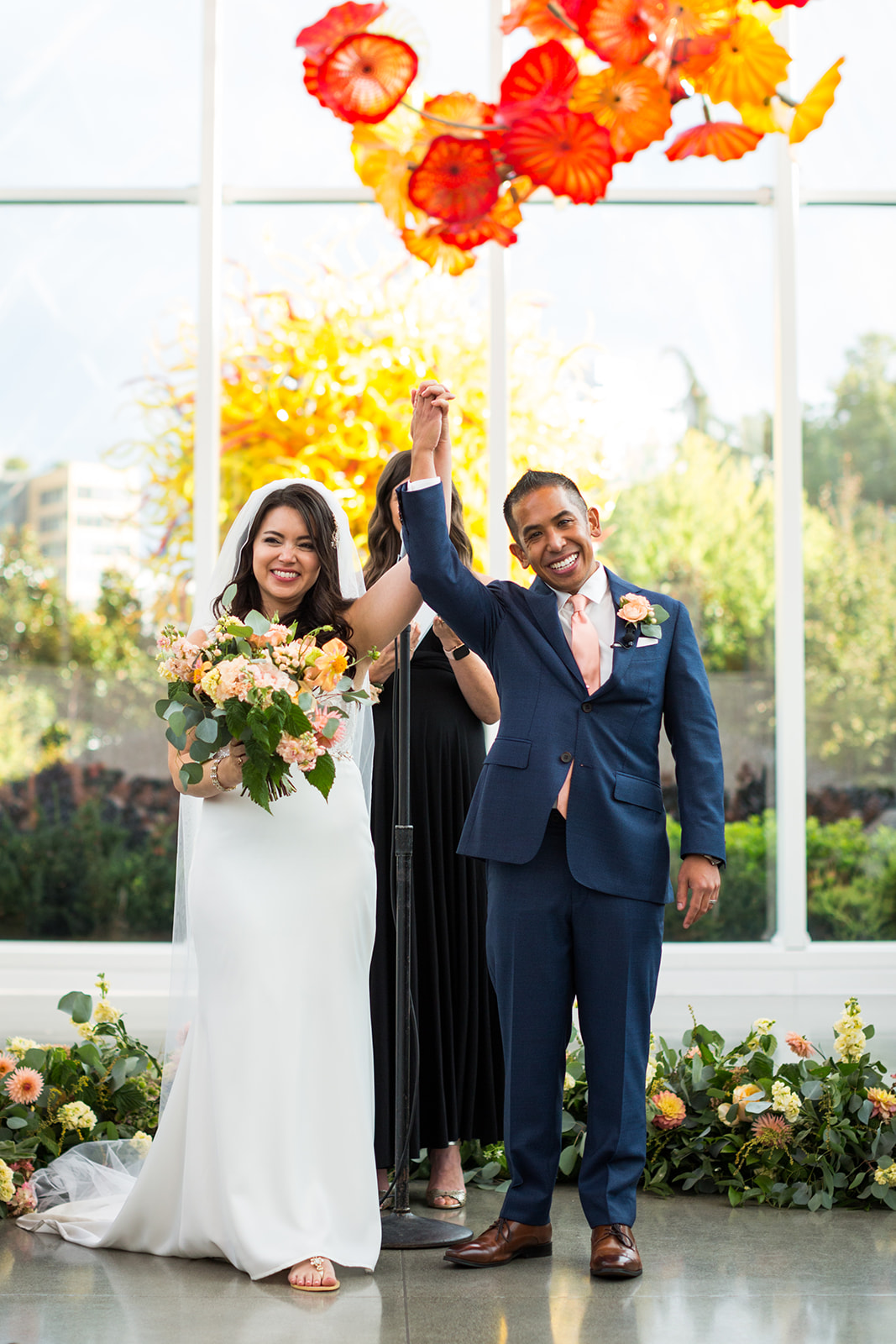 Bride and groom just married at their fall navy blue and burnt orange wedding at Chihuly | Flora Nova Design