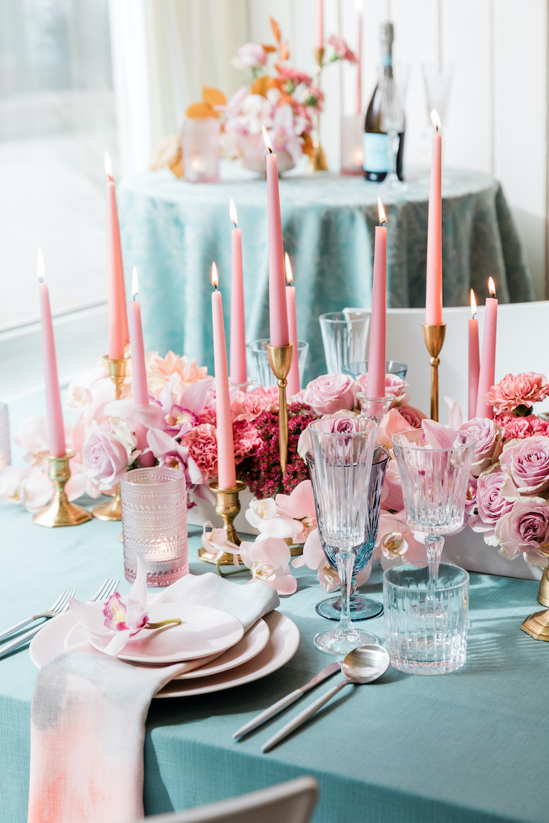 Romantic dinner date table set for two with pink and mauve floral mixed with teal accents.