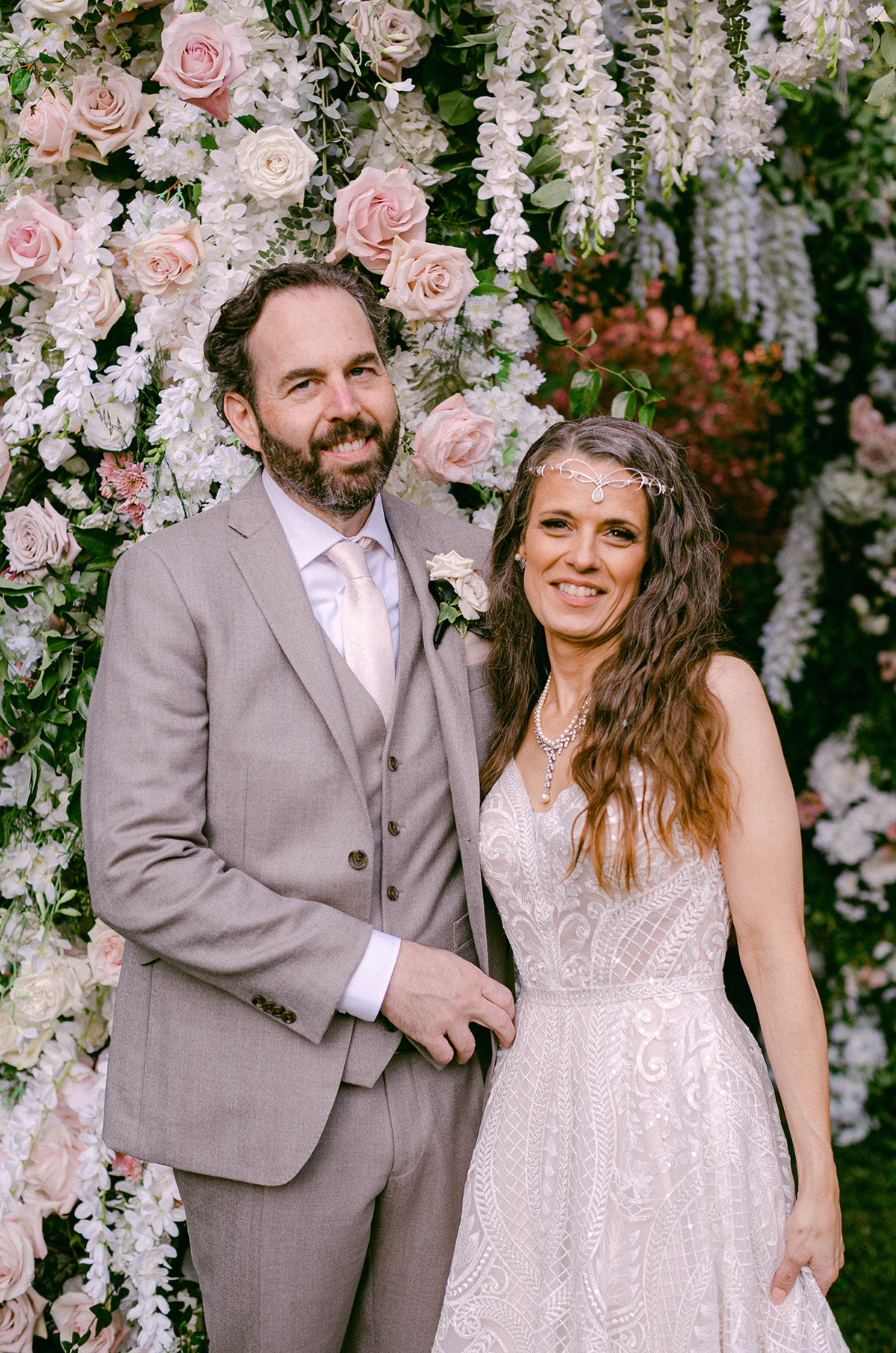 Bride and groom stand together in front of the enchanting lush chuppah.