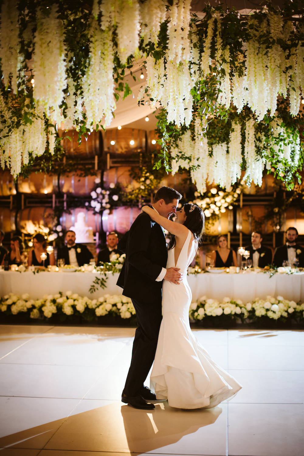 Bride and groom dance under the hanging wisteria ceiling installations at the Columbia Winery.