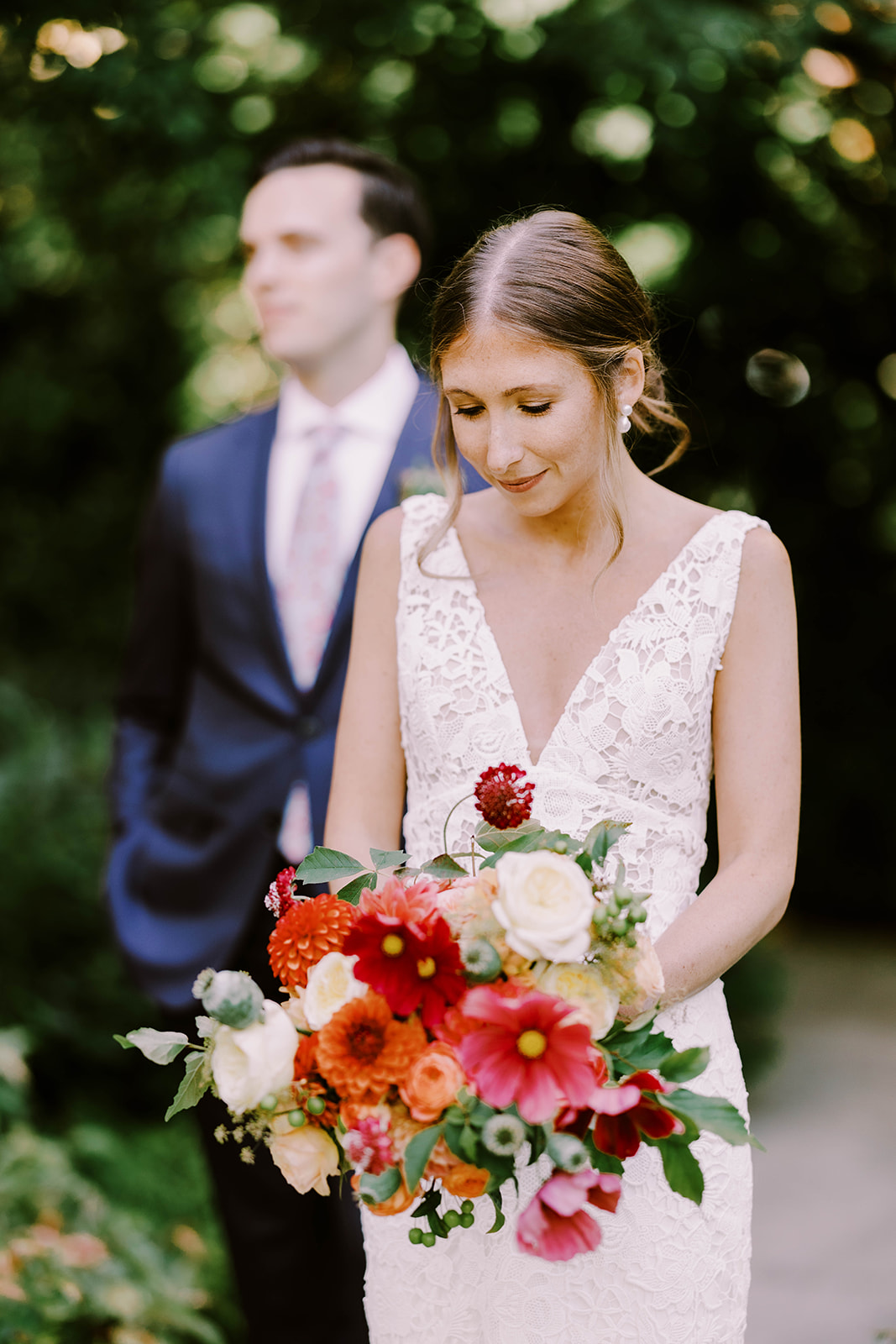 Bride smiles and holds her lush and vibrant bouquet filled with textures.