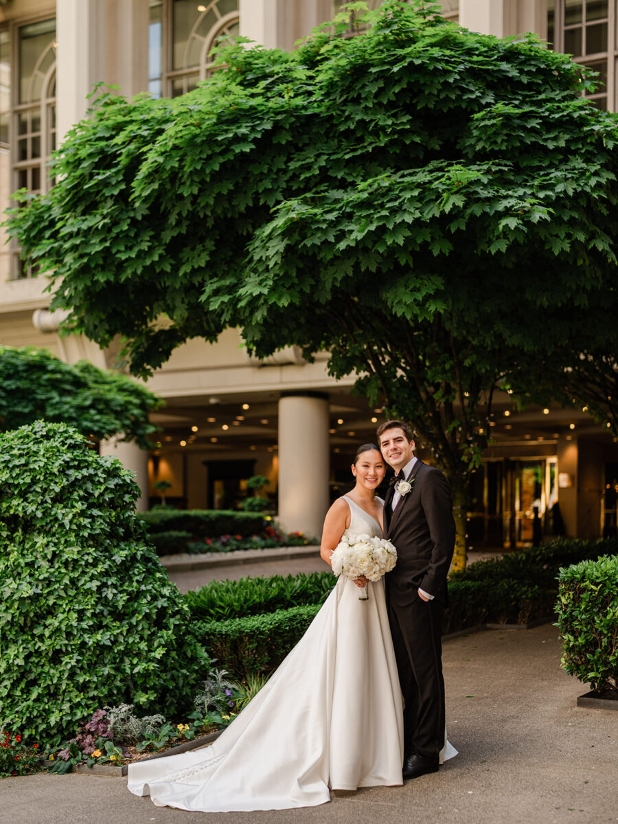 Bride and Groom stand in front of the Fairmont Olympic Hotel in Seattle