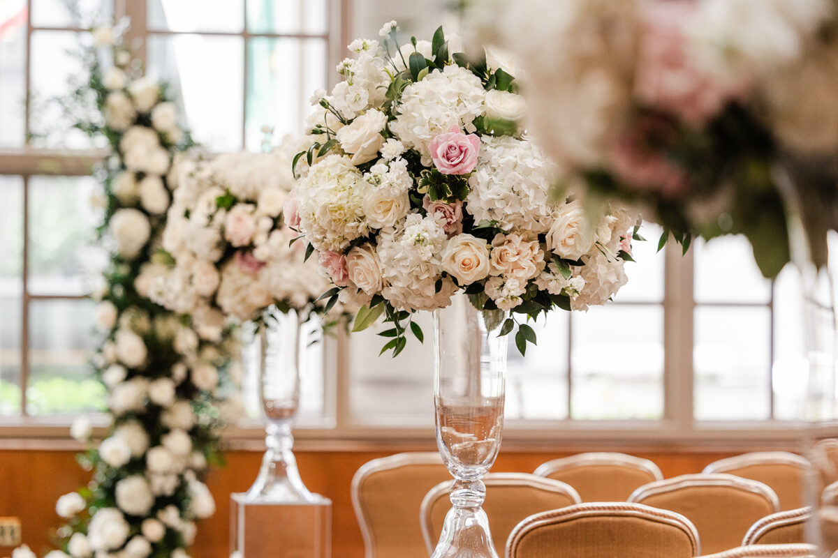 Charming white and blush arrangements designed with roses, hydrangeas, and Italian ruscus.