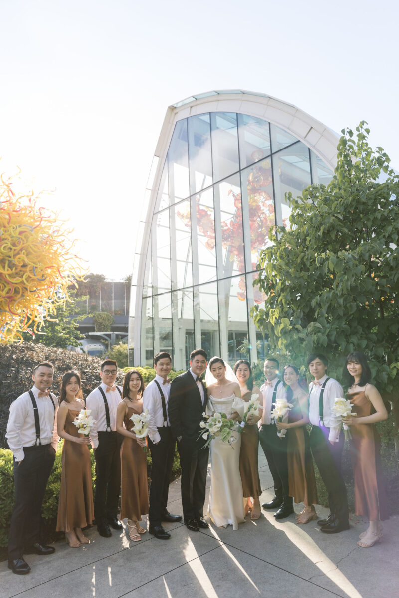 All of the bridal party and Groomsmen stand outside of the Chihuly Glass House on a lovely sunny Seattle day.