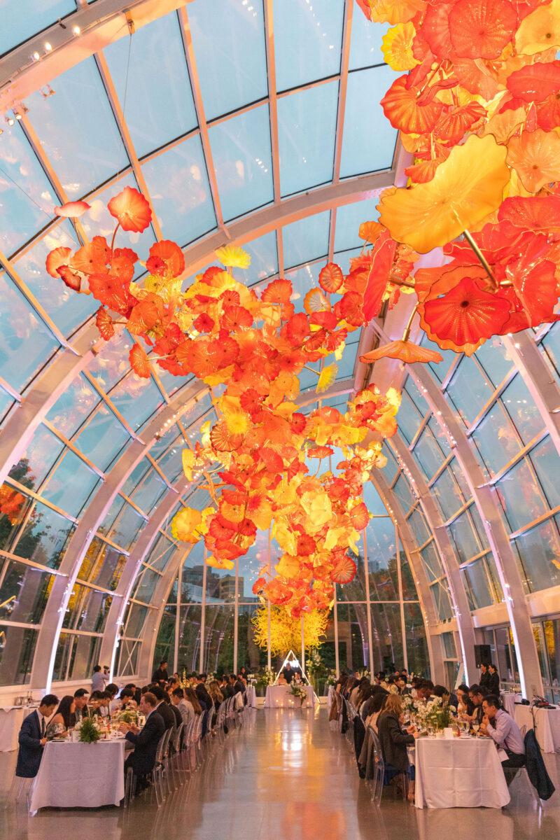 The guests sit and enjoy their meal in the decorated Chihuly Glass House.