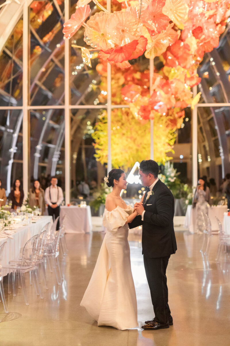 The bride and groom dance in the Chihuly Glass House.
