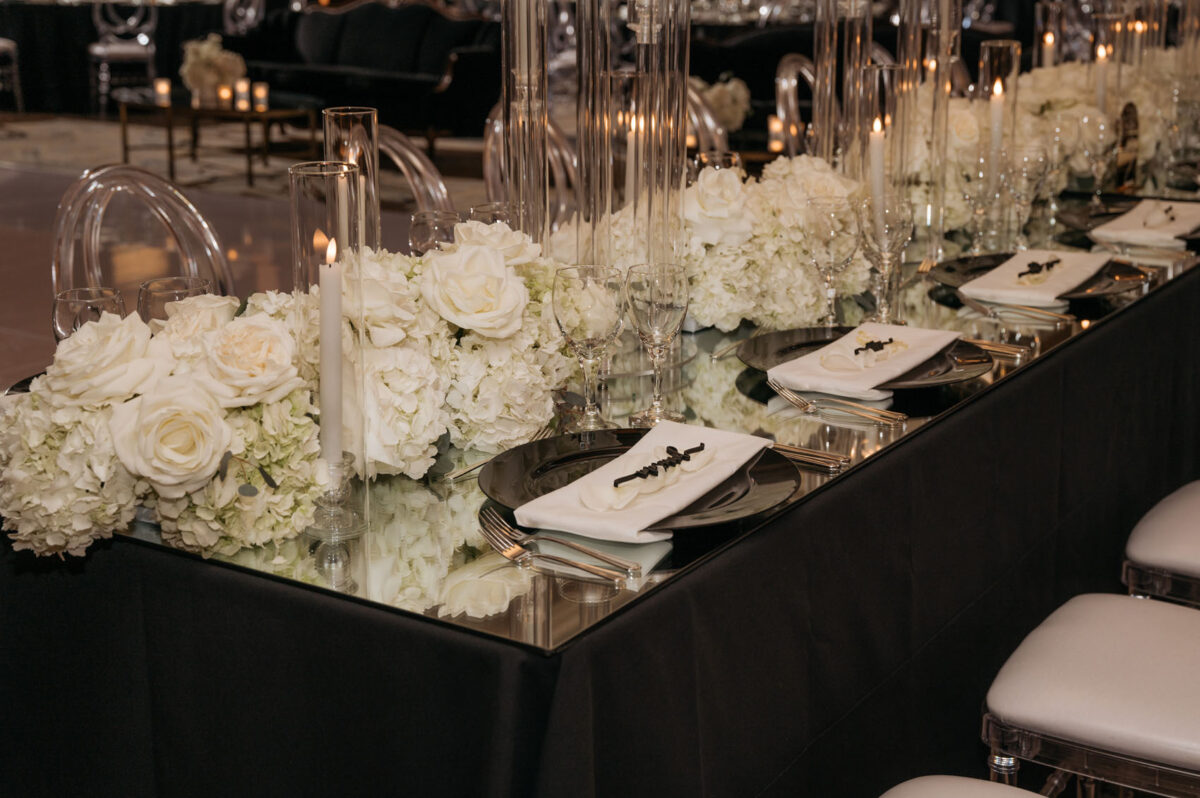 The head tables are designed with lush white floral arrangements and candles by Flora Nova Design Seattle.