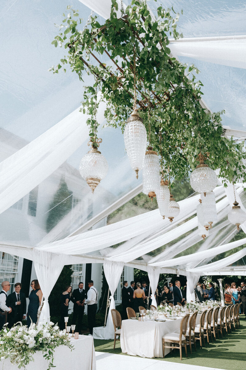 The Admiral's House tent ceiling is decorated with greenery and lights to illuminate the dance floor.