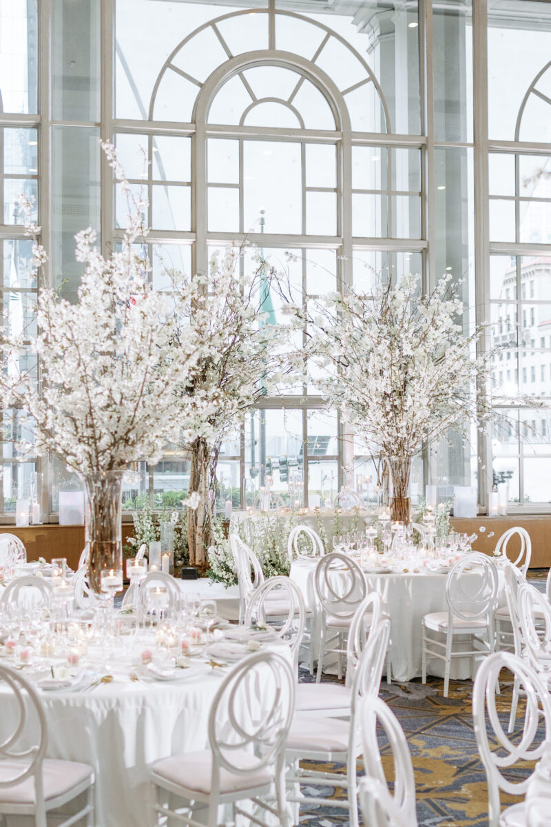 Lush and tall cherry blossom tree centerpieces are the focal point in the Garden room during the reception.