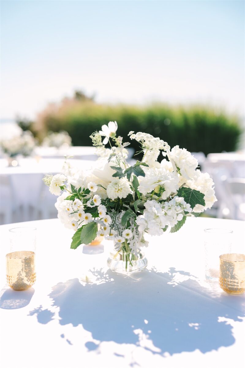 Delicate white centerpiece decorates the reception tables with votive candles.