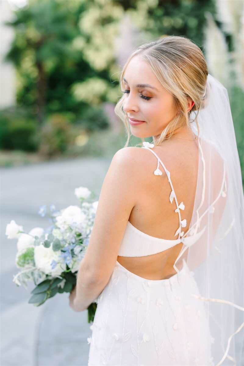 Stunning bride holds her bouquet with something blue.