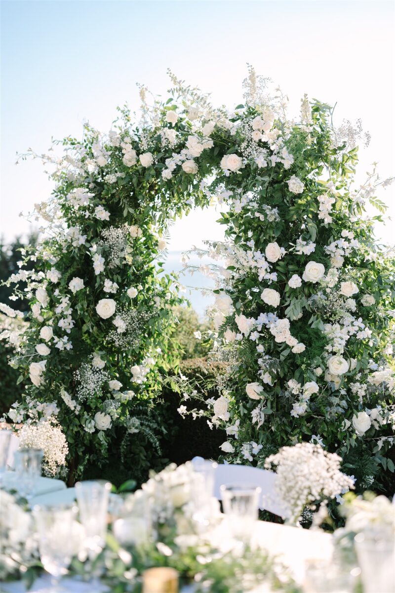 The lush white and green arch becomes the backdrop for the head table.