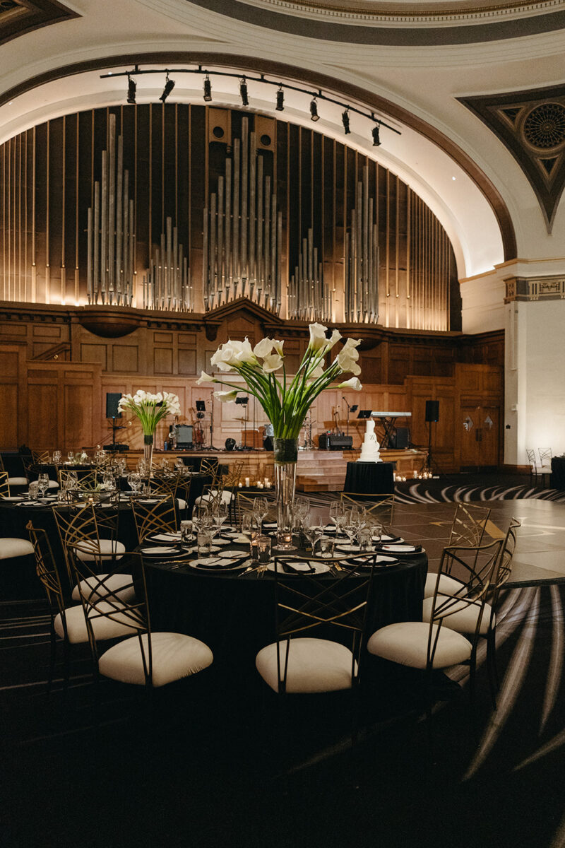 Dramatic reception space with tall white calla lily centerpieces and illuminated pipe organ at Elegant Hotel Lotte Wedding