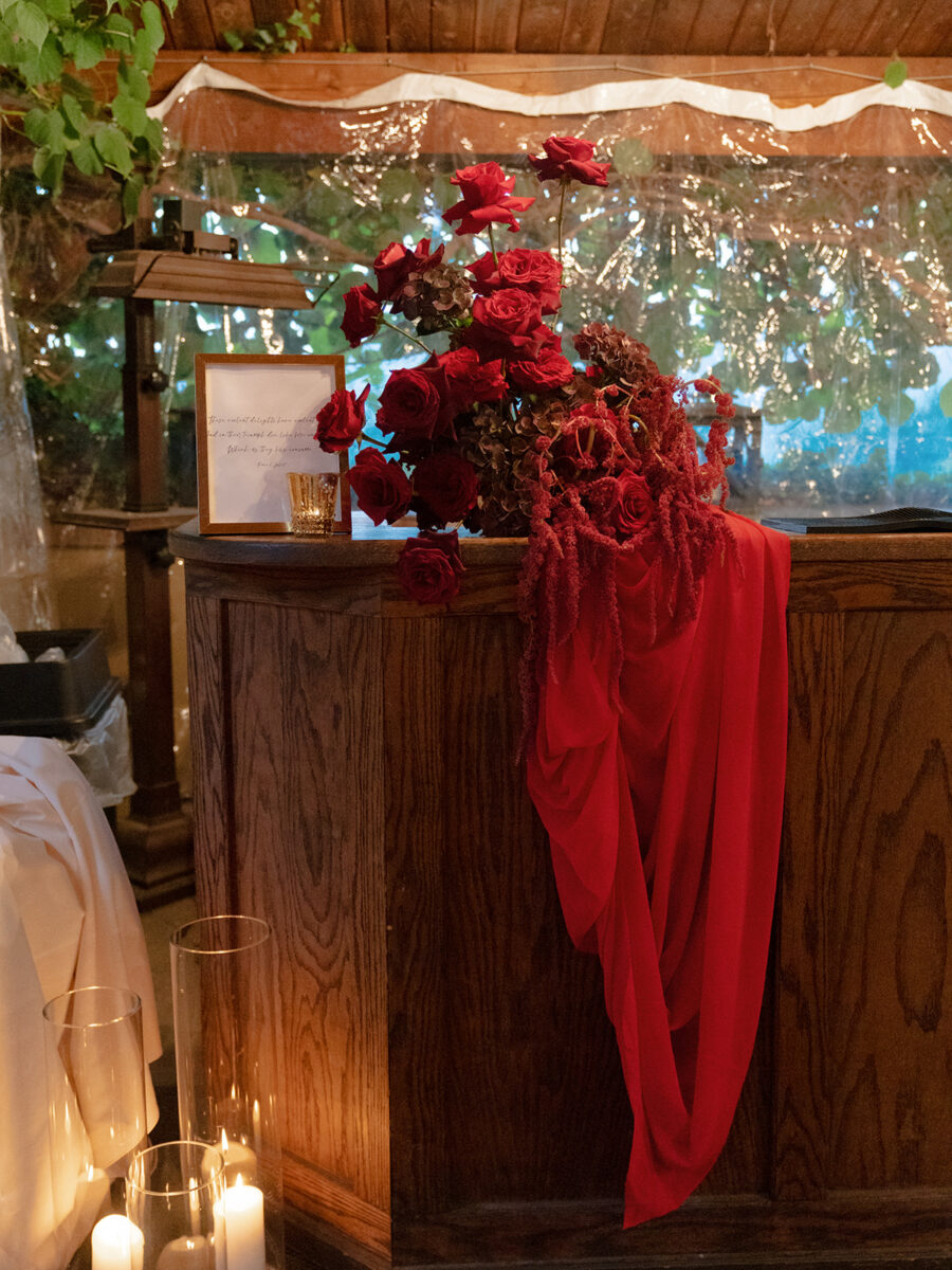 Bar arrangements accented with dramatic red floral designs and red fabric.