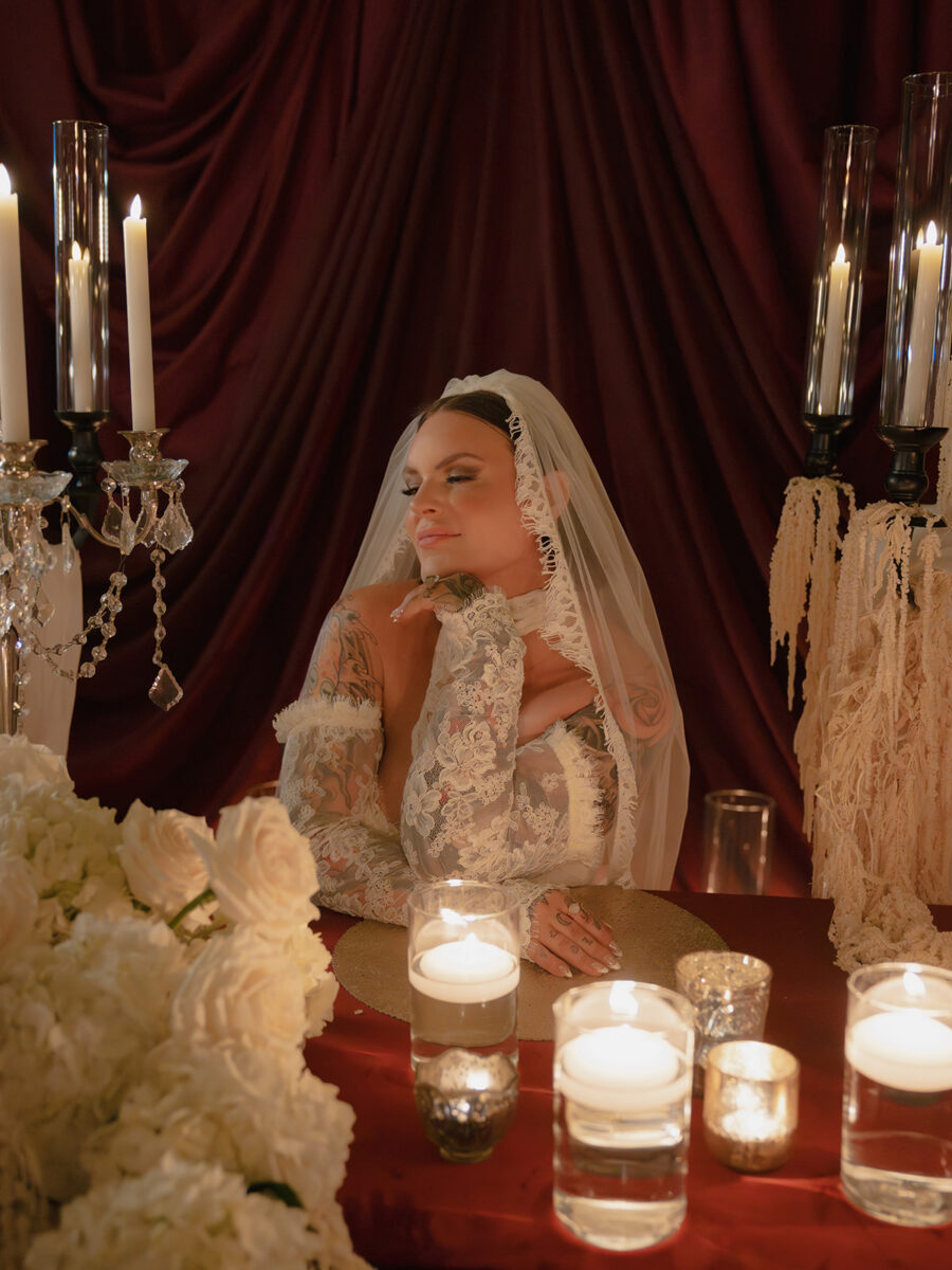 A sweet heart table with dramatic candelabras, floating candles, red linen and white floral designs.