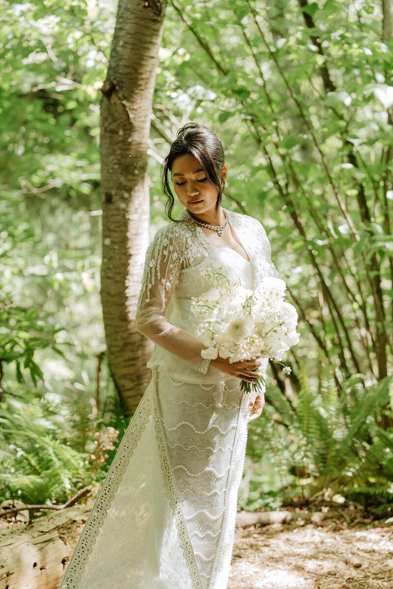 Bride holding her spring bouquet at a White Wedding at JM Cellars in Woodinville designed by Flora Nova Design.